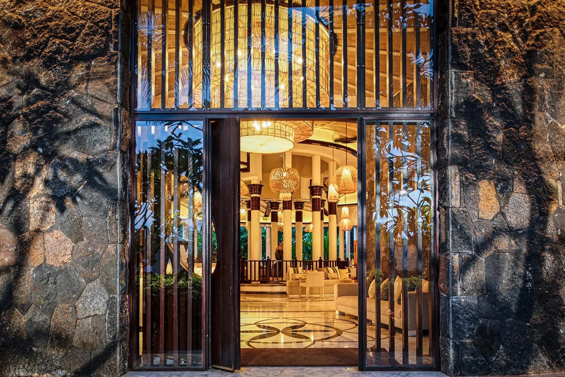 Veda restaurant entrance framed by volcanic stone walls at InterContinental Mauritius Resort Balaclava Fort