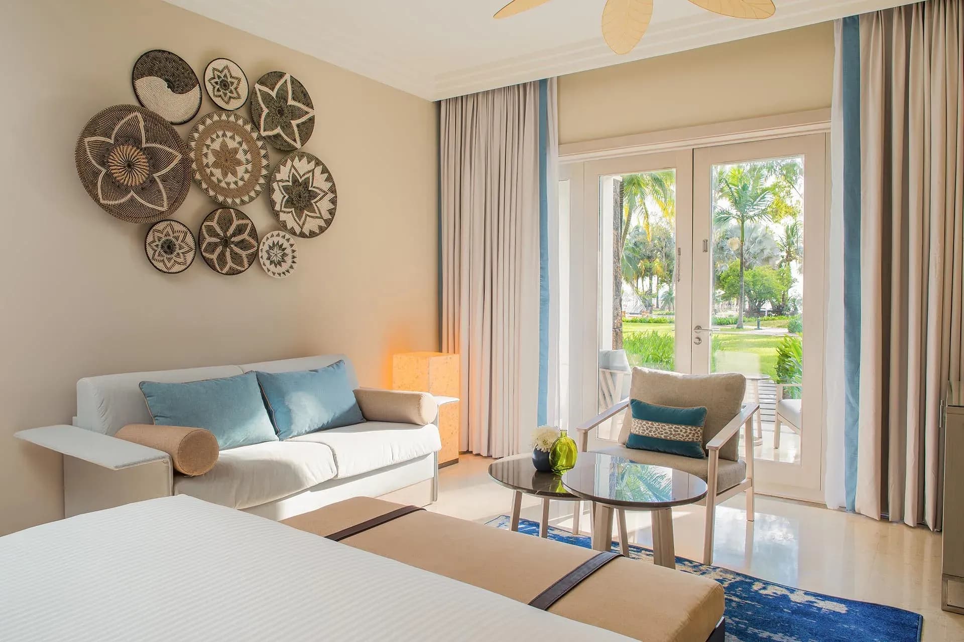 Deluxe Family Room living area with sofa bed opening onto a garden terrace at InterContinental Mauritius Resort Balaclava Fort