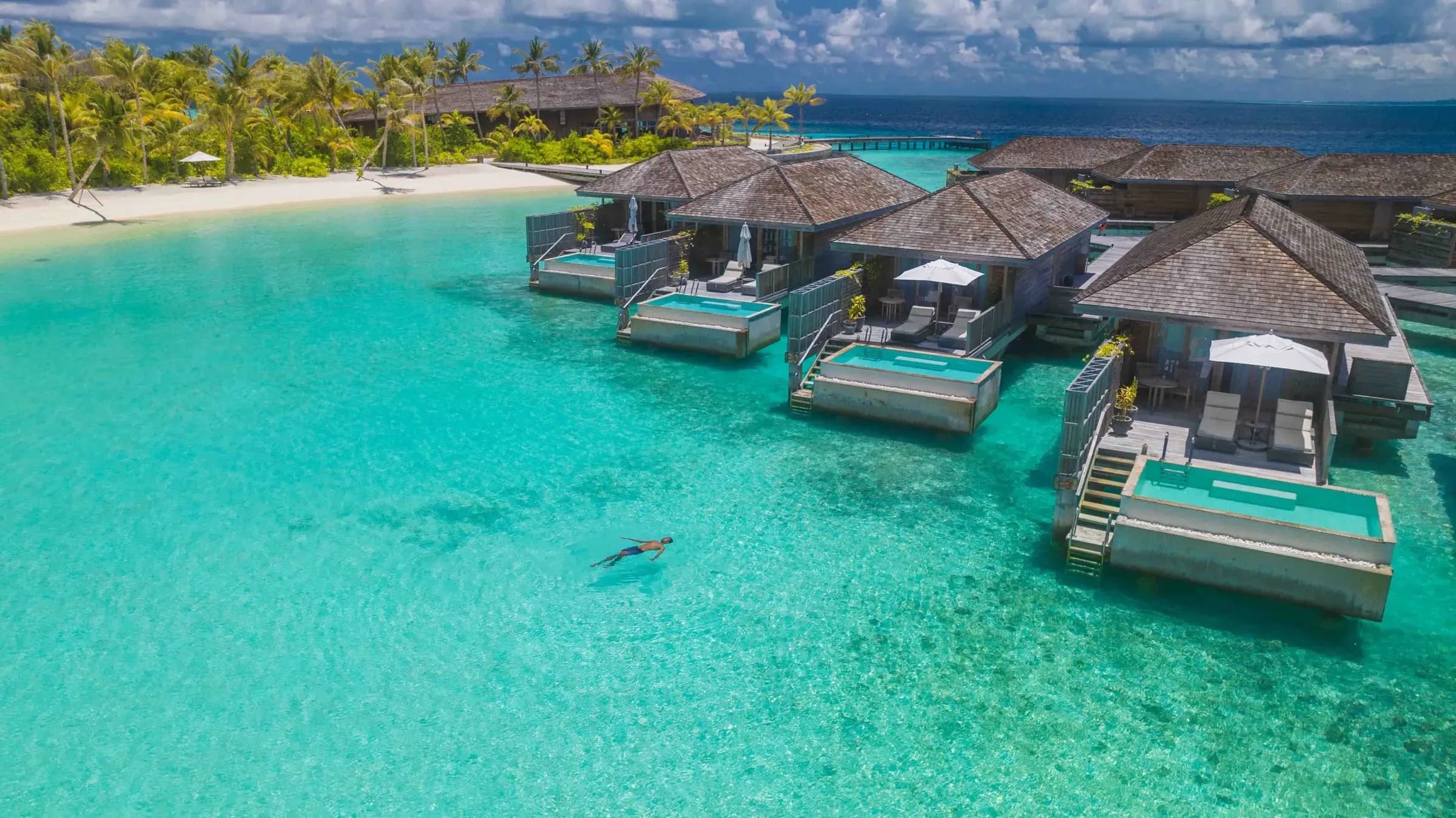 Lagoon Pool Villas over the turquoise lagoon with island beach in view at Kagi Maldives