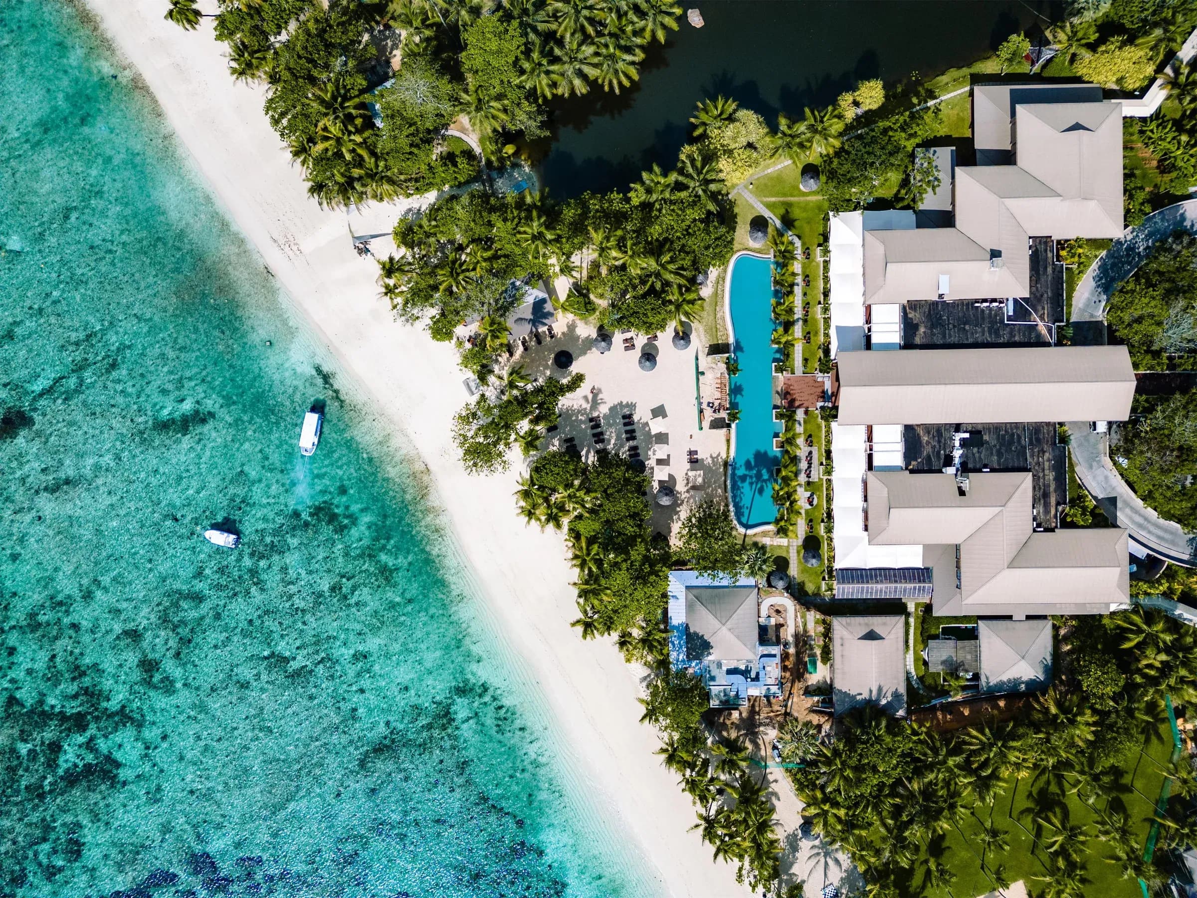 Palm-fringed sandy beach at Kempinski Seychelles Resort, Baie Lazare
