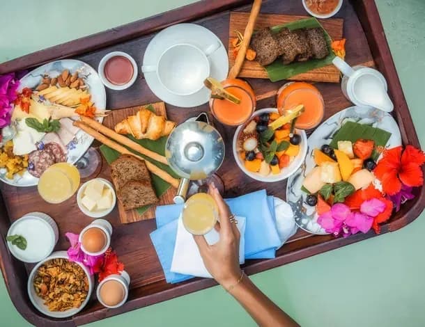 Floating breakfast tray of pastries, fruit and juices served in a villa's private pool at Kilindi Zanzibar
