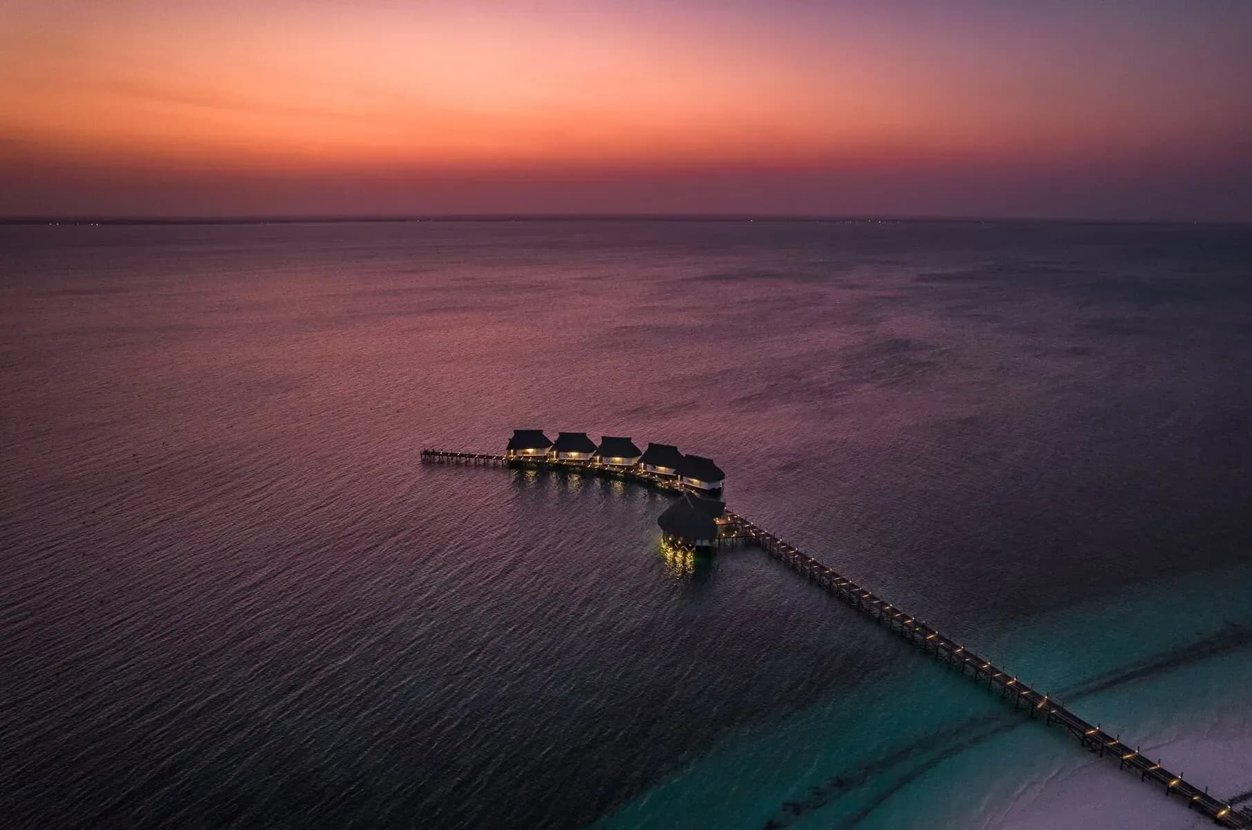 Dusk view of the Isaraya jetty and overwater villas reaching into Chwaka Bay