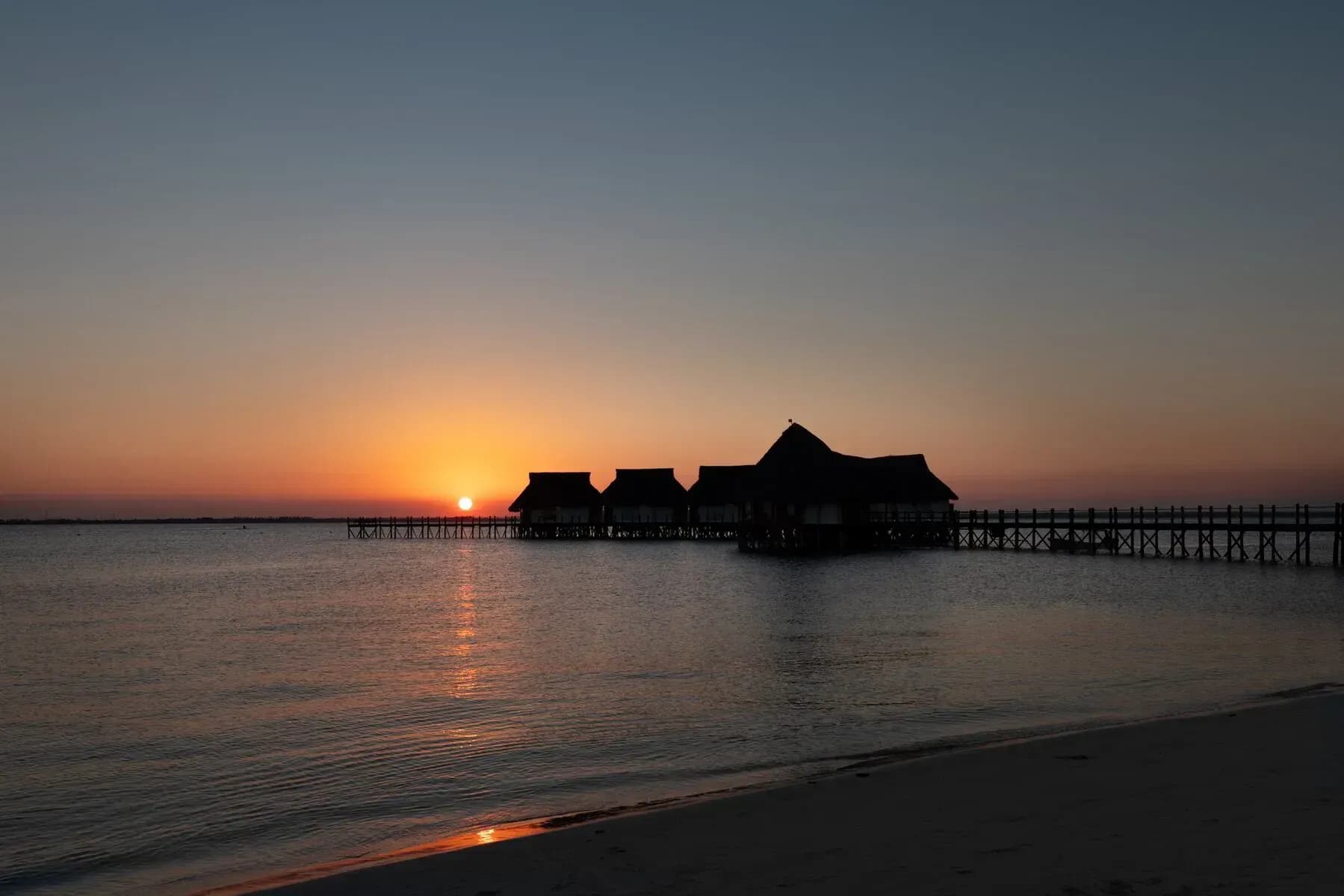Sunset aerial view of the Isaraya overwater villas jetty at Konokono Beach Resort, Chwaka Bay, Zanzibar