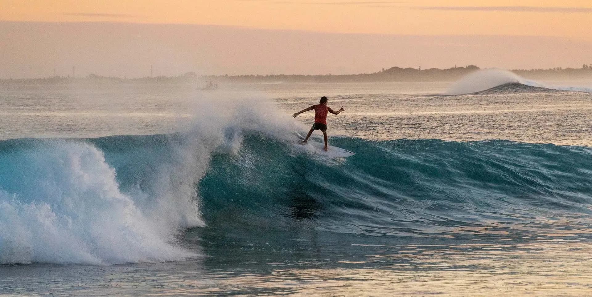 Surfer riding a wave at Chicken's Break, the surf point beside Kuda Villingili Resort Maldives