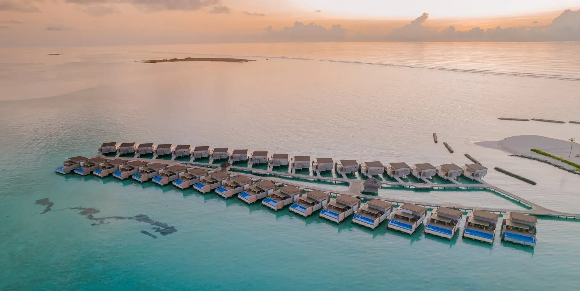 Sunset Water Villa with Private Pool at dusk at Kuda Villingili Resort Maldives