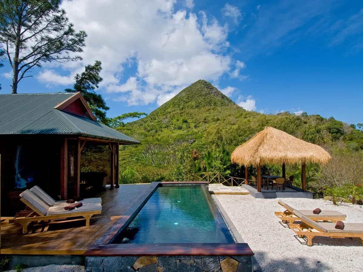 Private pool and sun loungers of a Sea View Pool Suite with Piton Canot mountain in view