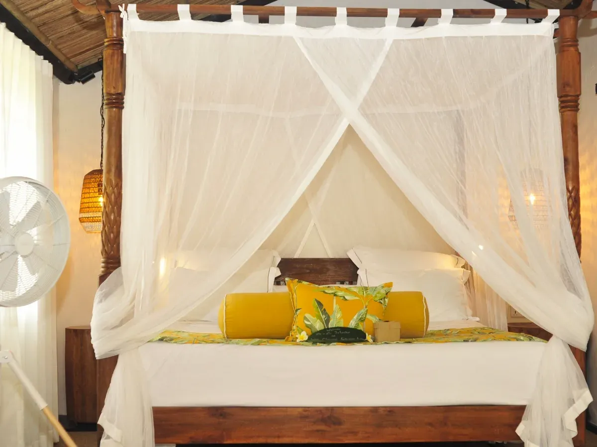 Suite bedroom with mosquito-net canopy bed at Lakaz Chamarel Exclusive Lodge