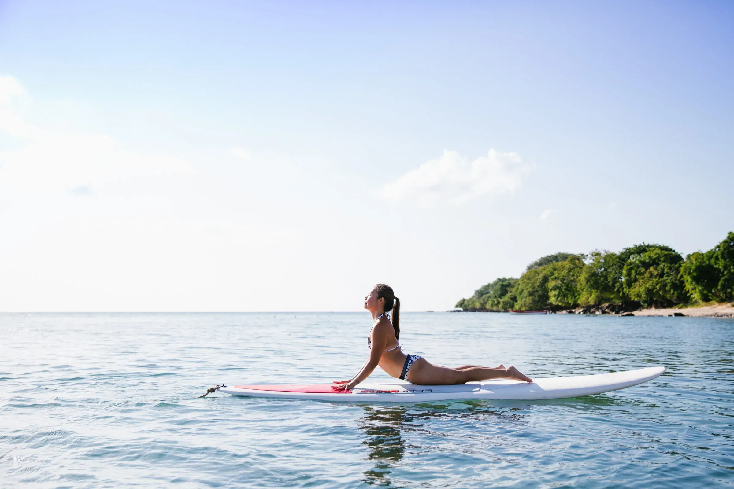Guest practising paddleboard yoga in Turtle Bay at Le Jadis