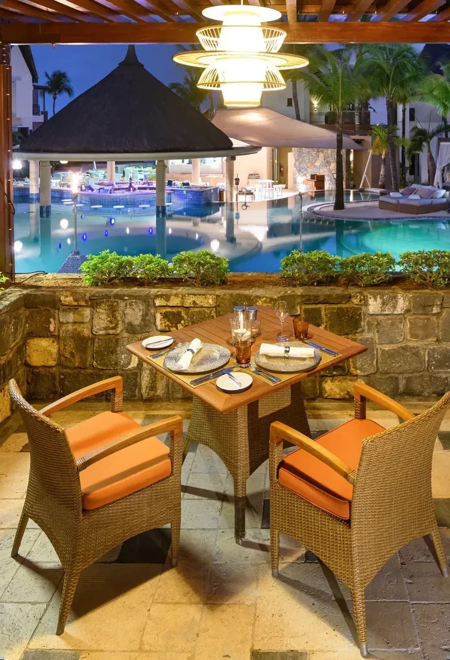 Oryza restaurant overlooking the illuminated pool at Le Jadis