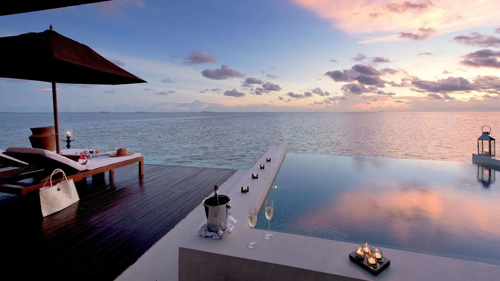Sunset Water Suite private deck at dusk, Lily Beach Resort & Spa