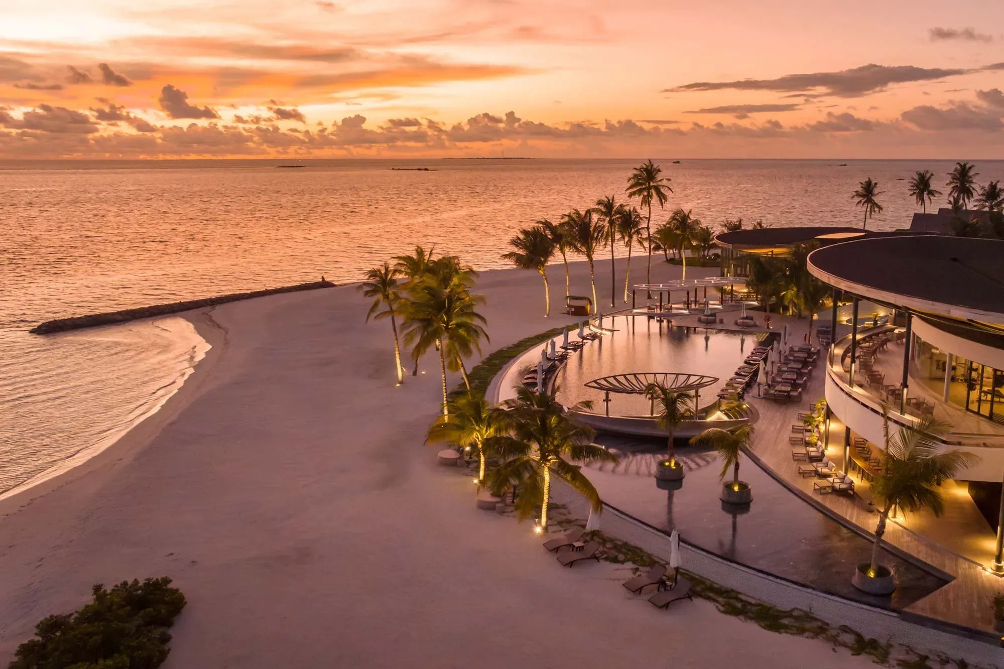Aerial sunset view of the beach club pool and lounge deck at Madifushi Private Island