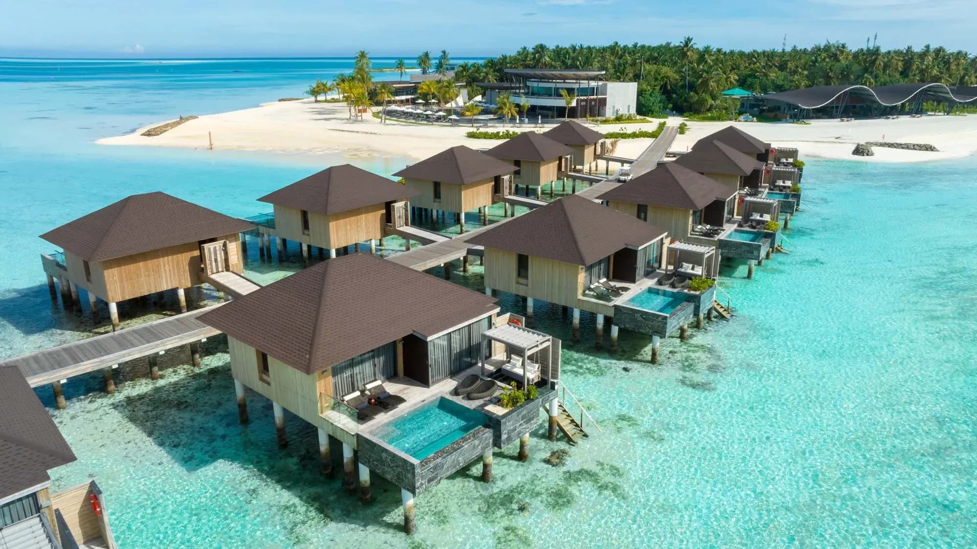 Aerial view of overwater villas and beach at Madifushi Private Island, Meemu Atoll