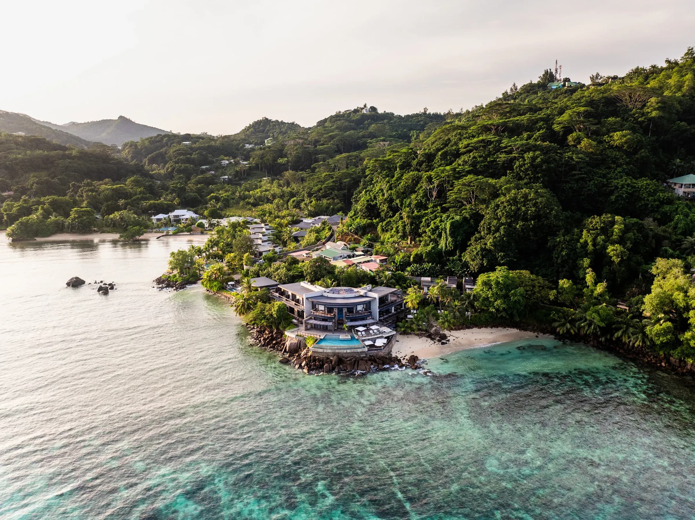 Aerial view of Mango House Seychelles' cliffside pool and private beach at Anse aux Poules Bleues, Mahé