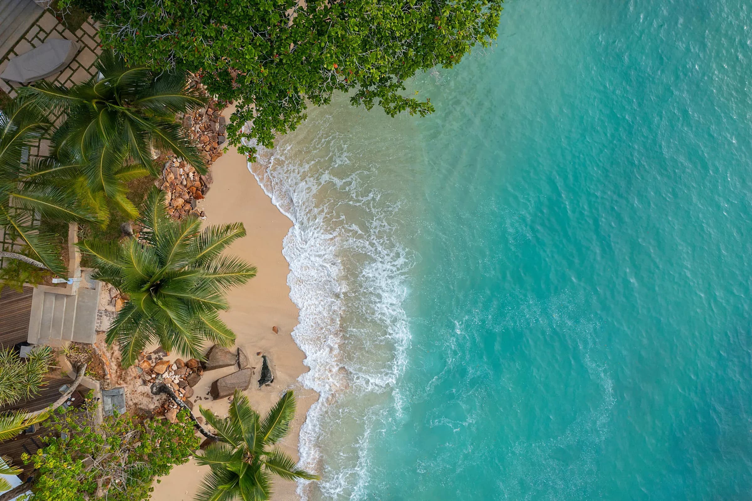 Aerial view of the resort's headland and turquoise bay on Mahé's south-west coast