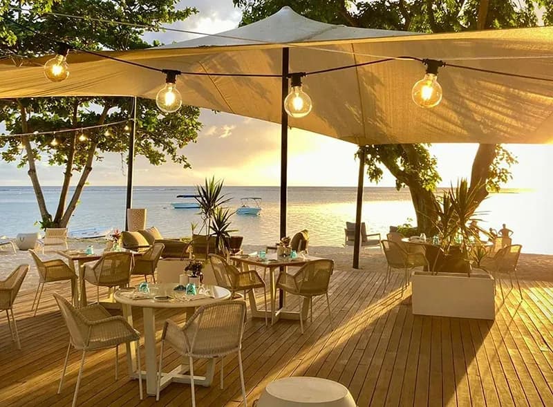 Sunset dining tables on the beach deck at Beach House Grill, Maradiva