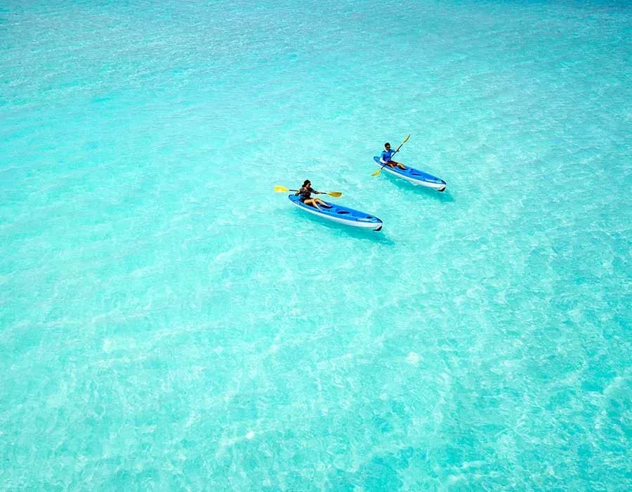 Guests kayaking on the clear lagoon at Milaidhoo