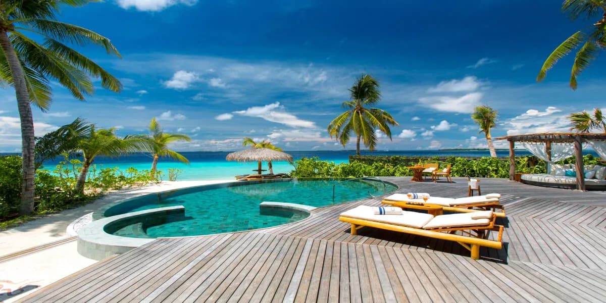 Beach Pool Residence pool deck facing the lagoon at Milaidhoo