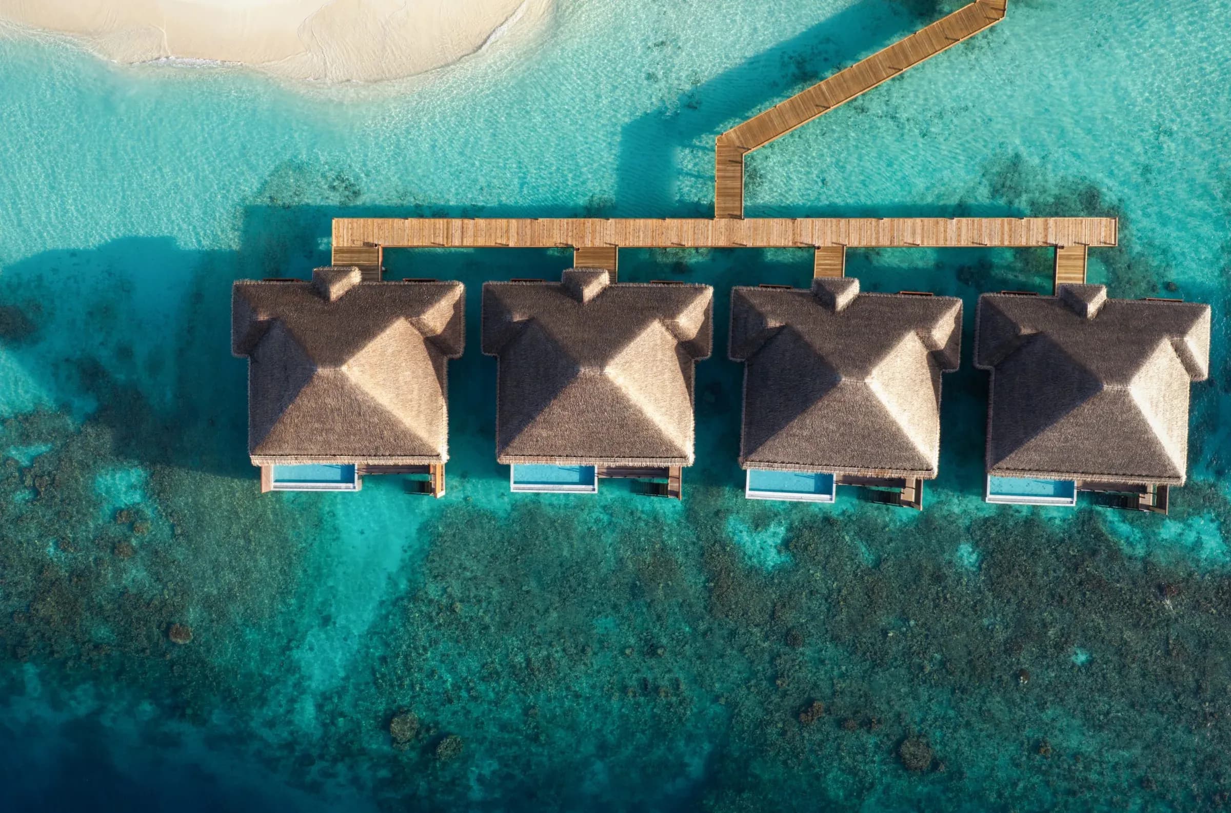 Aerial view of fan-shaped overwater pool villas over the house reef at V Villas Maldives at Mirihi