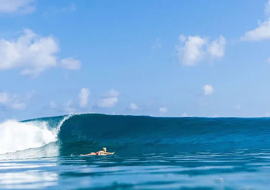 Surfer riding a wave at Vodi Point, Niyama Private Islands Maldives