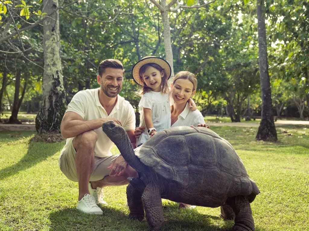 Family with an Aldabra giant tortoise on North Island, Seychelles