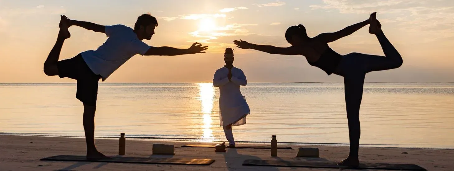 Sunset yoga session on the beach at OZEN LIFE MAADHOO