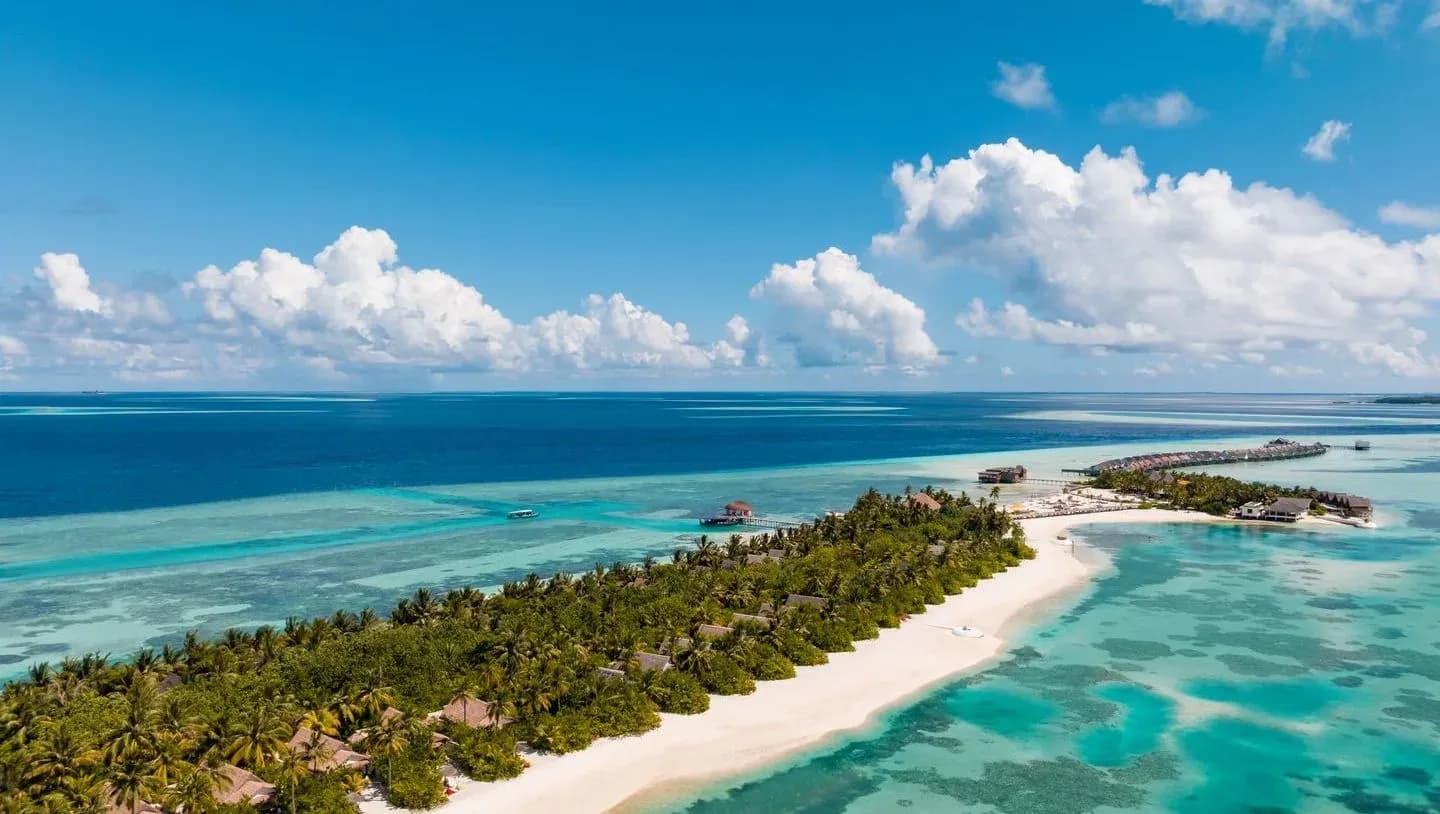 Aerial view of OZEN LIFE MAADHOO island with overwater villas and reef, South Malé Atoll