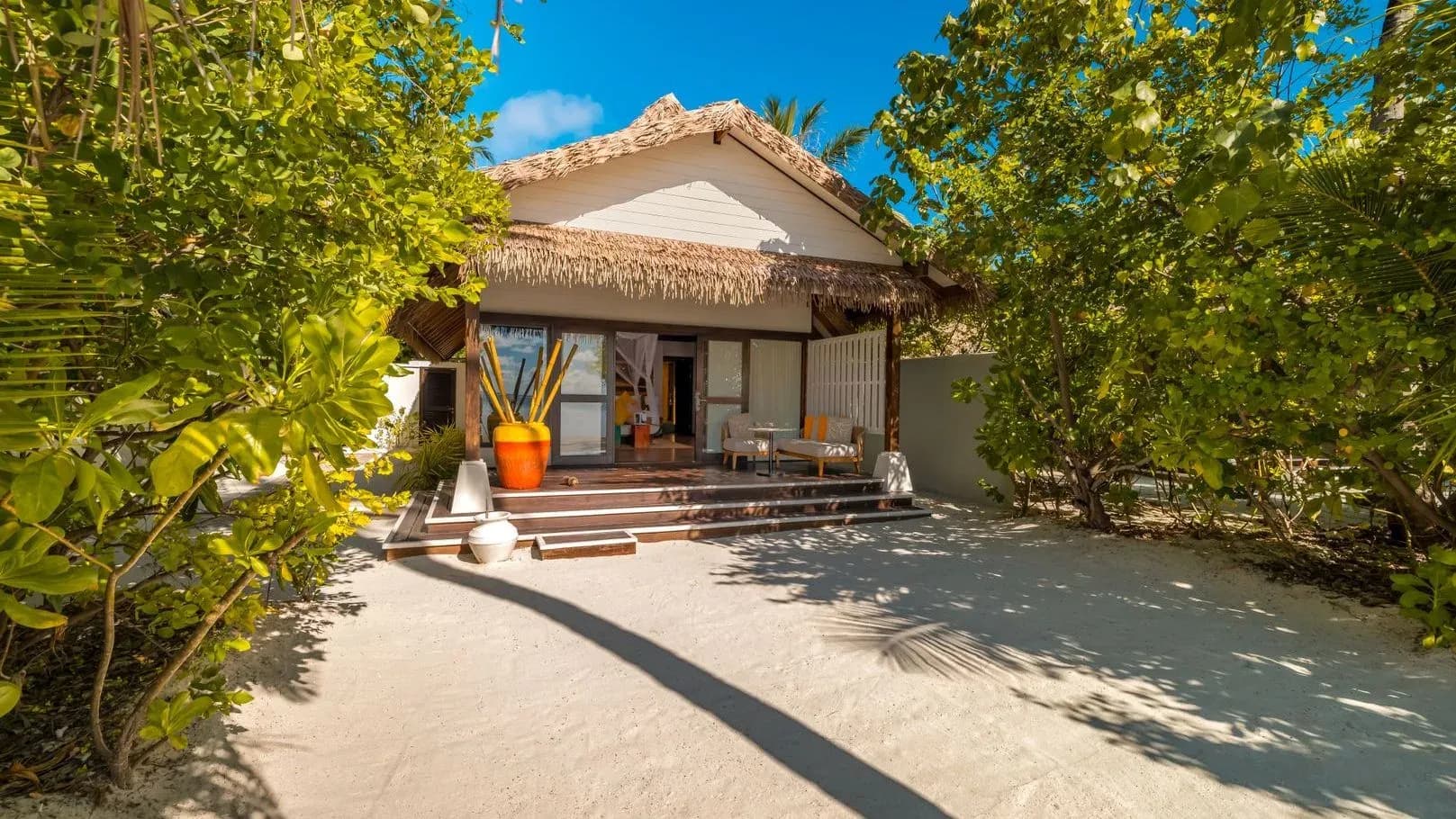 Earth Villa exterior with thatched roof and beachfront garden at OZEN LIFE MAADHOO