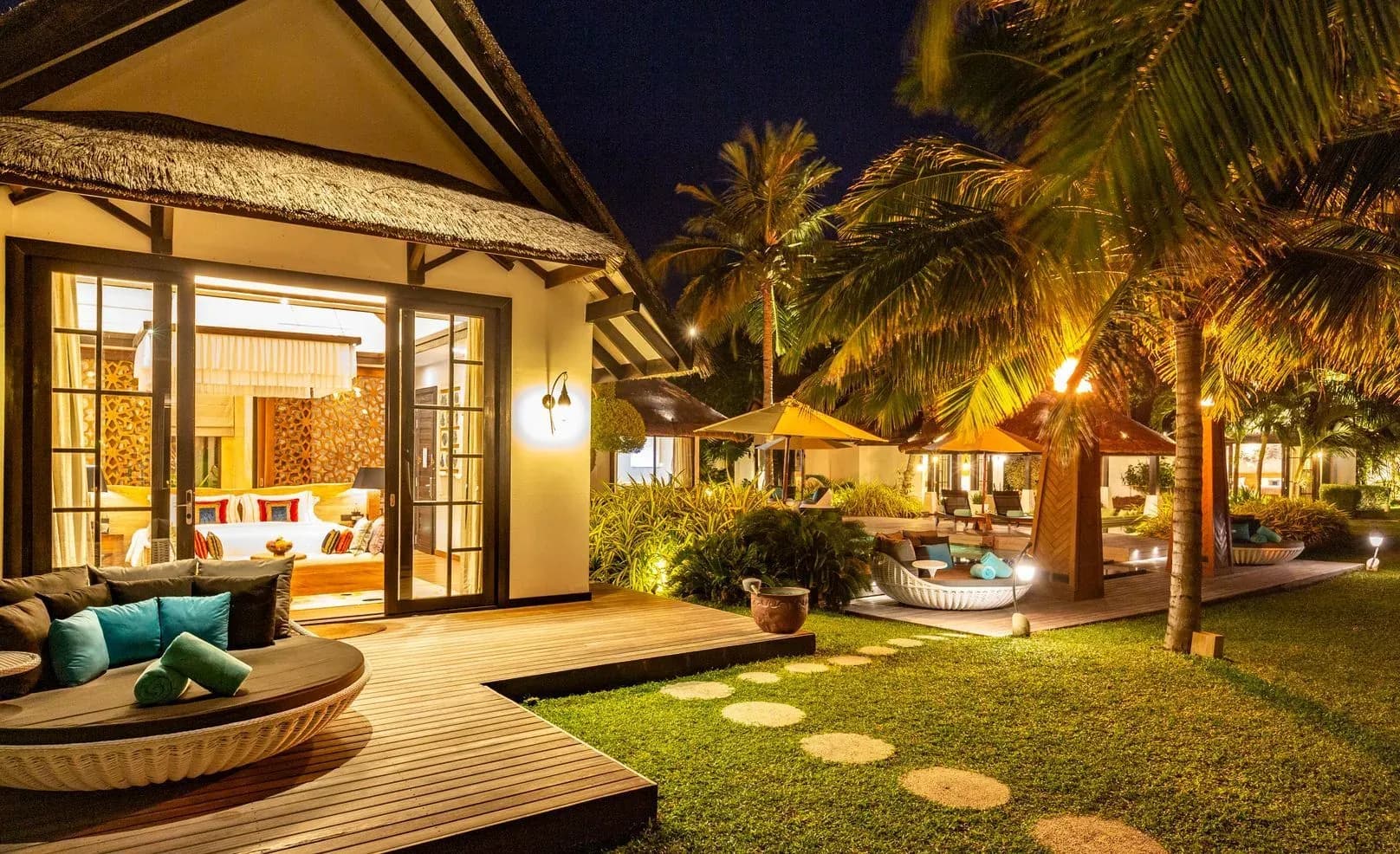 Pool villa terrace with sun loungers and thatched roofs at OZEN RESERVE BOLIFUSHI