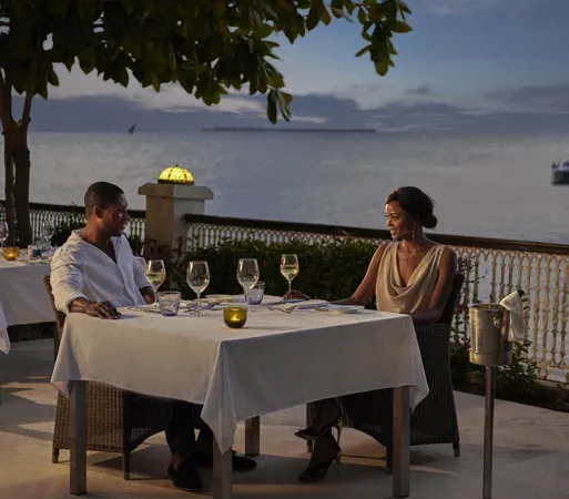 Guests dining on the oceanfront terrace at Zamani Residence, Park Hyatt Zanzibar, at dusk