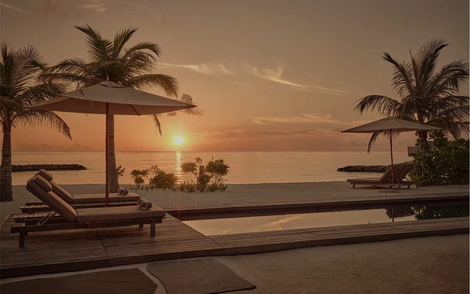 Sunset glow over the pool deck of a One Bedroom Sunset Beach Pool Villa, Patina Maldives