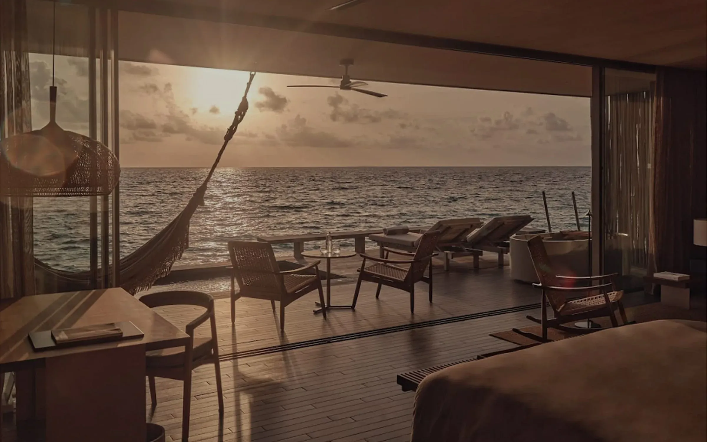 Sunset light through open doors of a One Bedroom Sunset Water Pool Villa, Patina Maldives