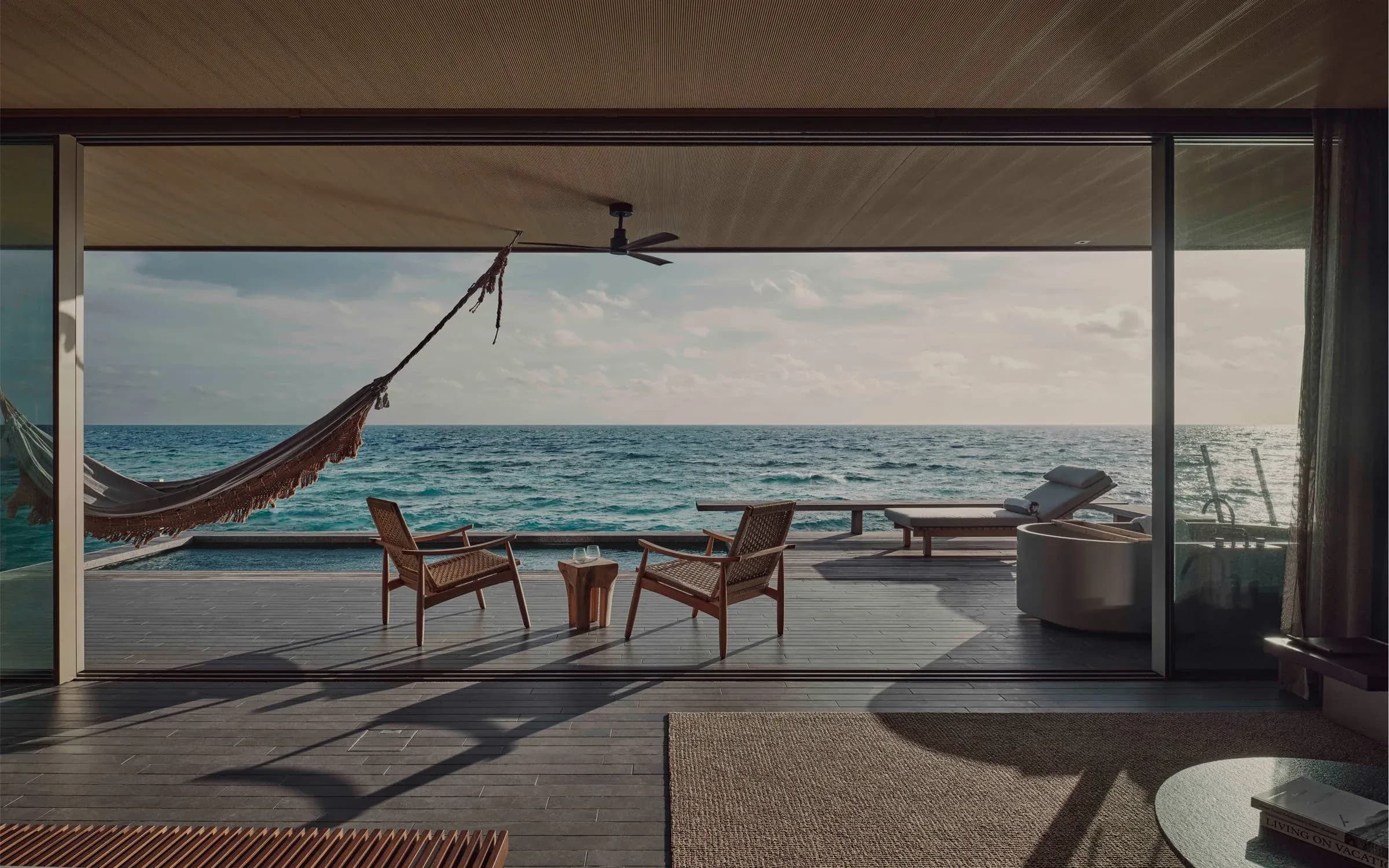 Deck and hammock overlooking the ocean at a One Bedroom Water Pool Villa, Patina Maldives