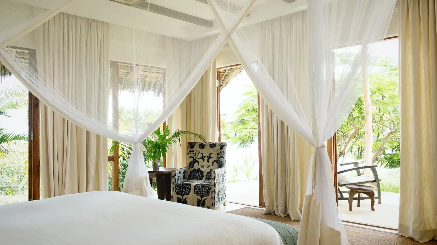 Africa Villa bedroom at Qambani Luxury Resort with tribal textiles and a sea-view verandah
