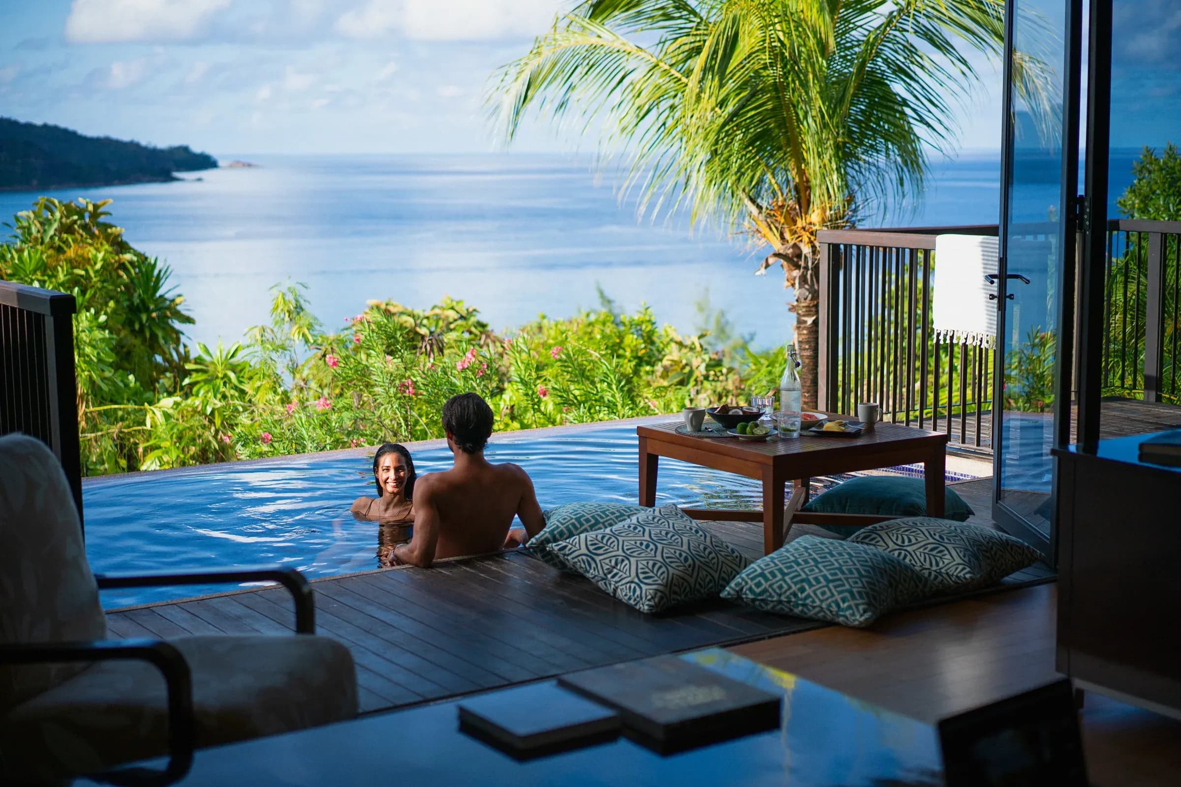 Guests relaxing in a private plunge pool overlooking the Indian Ocean at Raffles Seychelles