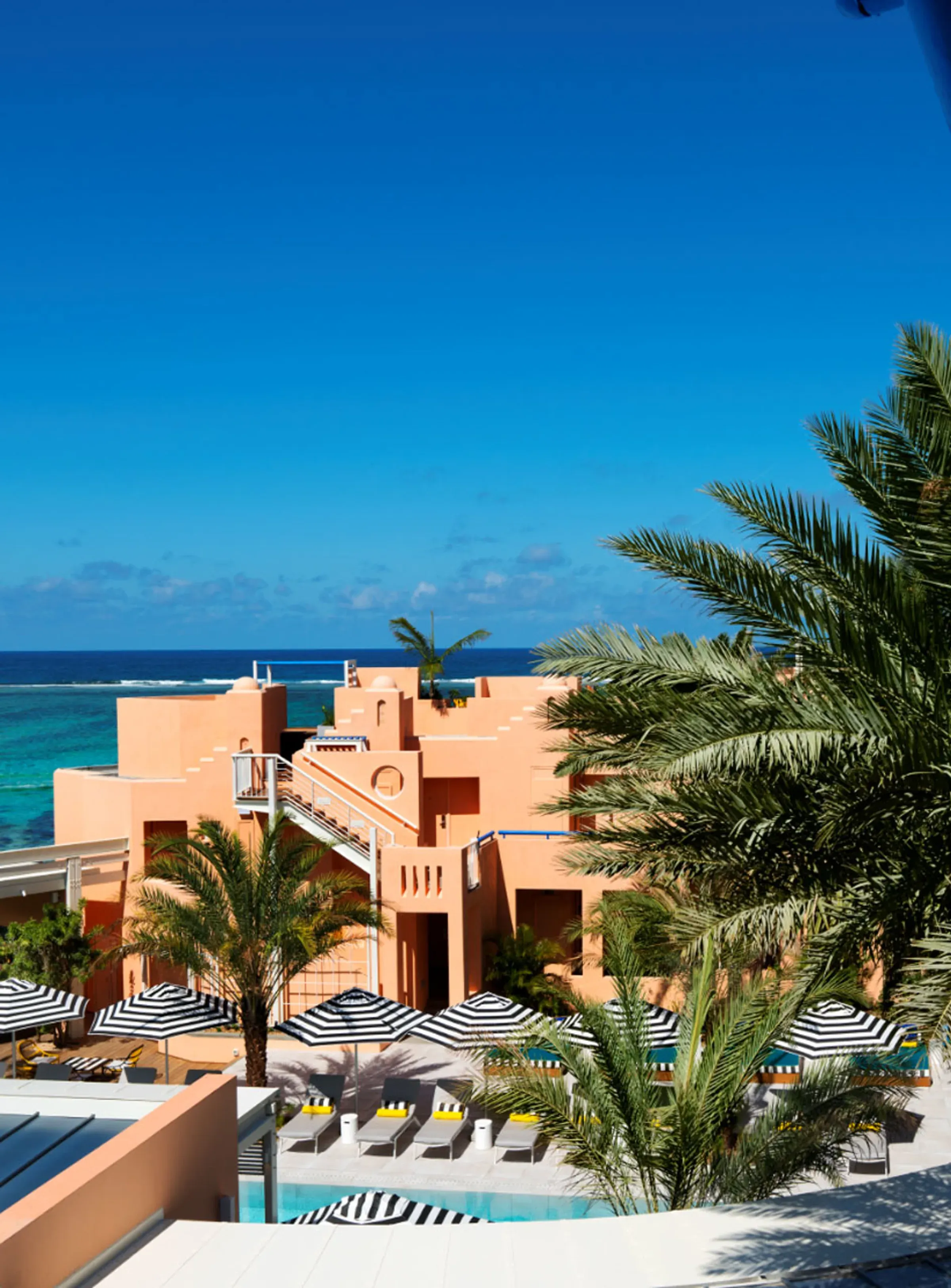 View of the pool deck and pink pavilions from a Pool Plus room balcony at SALT of Palmar