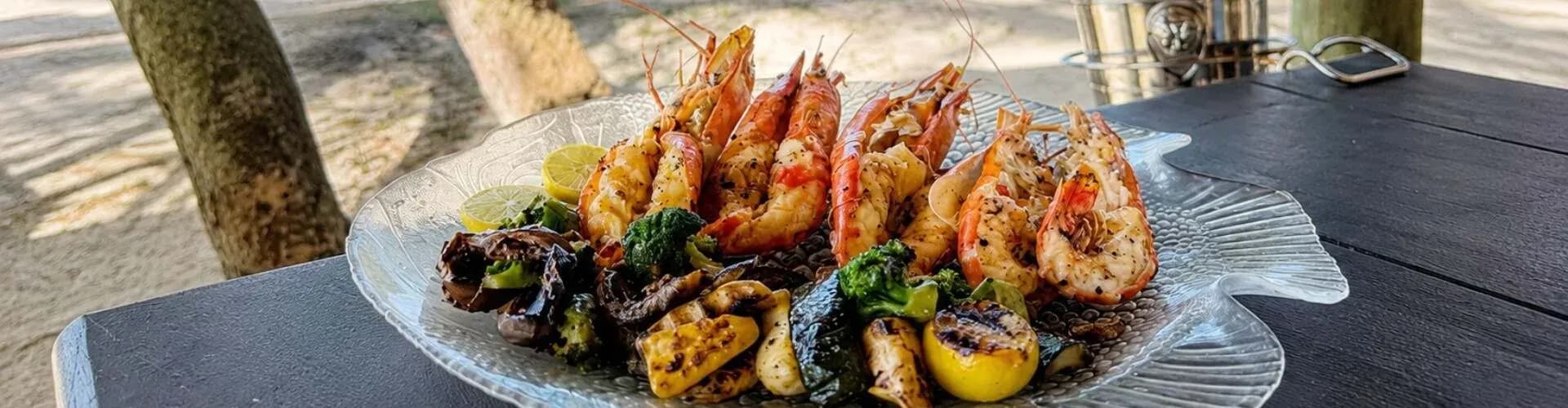 Grilled prawns served under the trees on Ilot Mangénie, Shangri-La Le Touessrok's private island