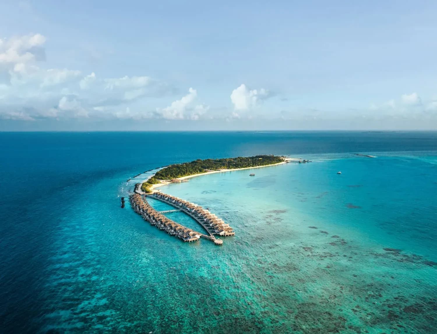 Aerial view of Sirru Fen Fushi's overwater villas and reef in Shaviyani Atoll, Maldives