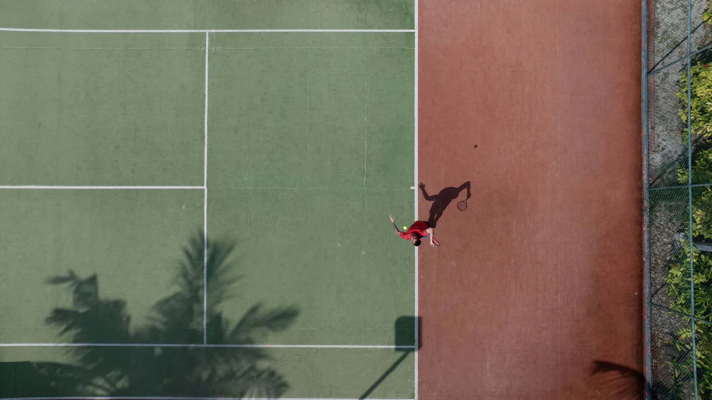 A guest playing on the tennis court at Six Senses Kanuhura