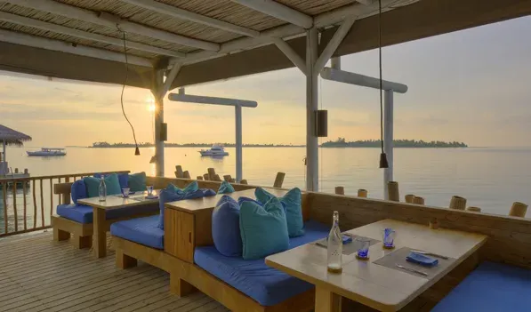 Sip Sip open-air deck seating at sunset, Six Senses Laamu