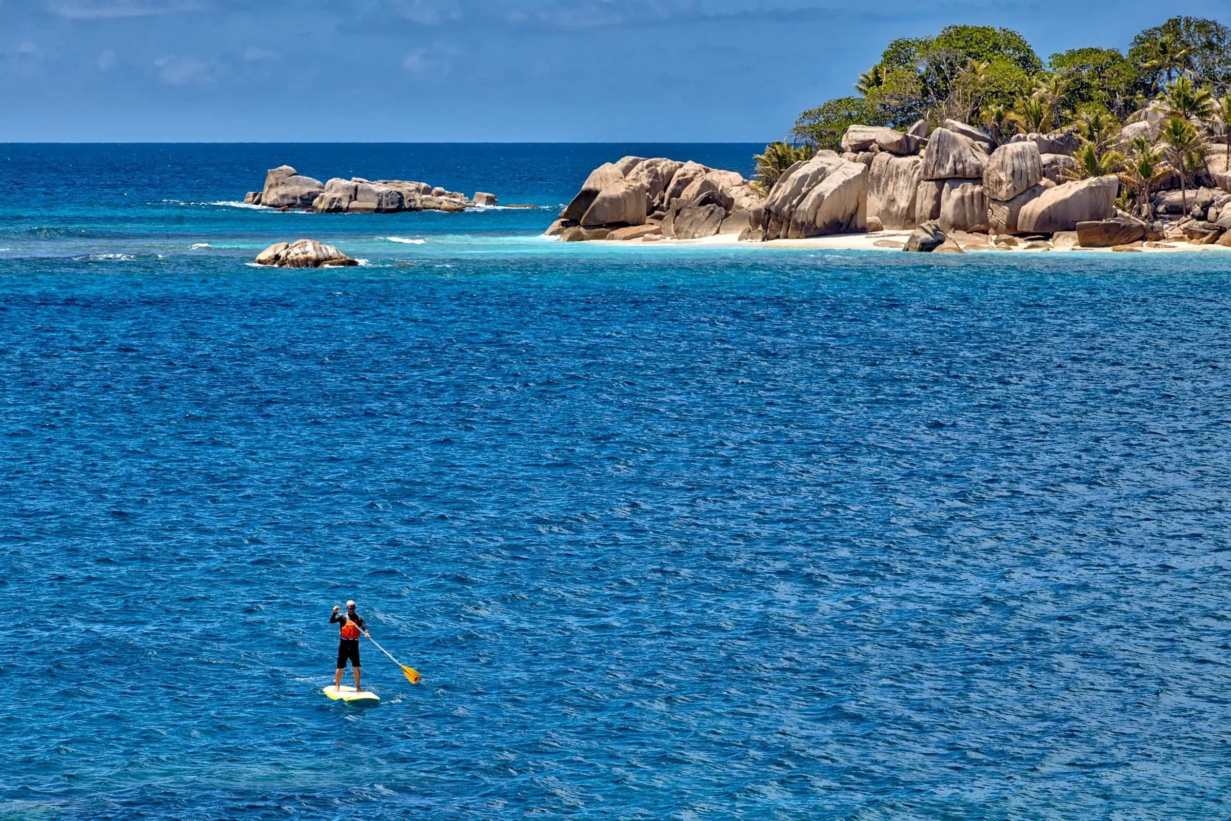 Stand-up paddleboarding near Koko Island at Six Senses Zil Pasyon