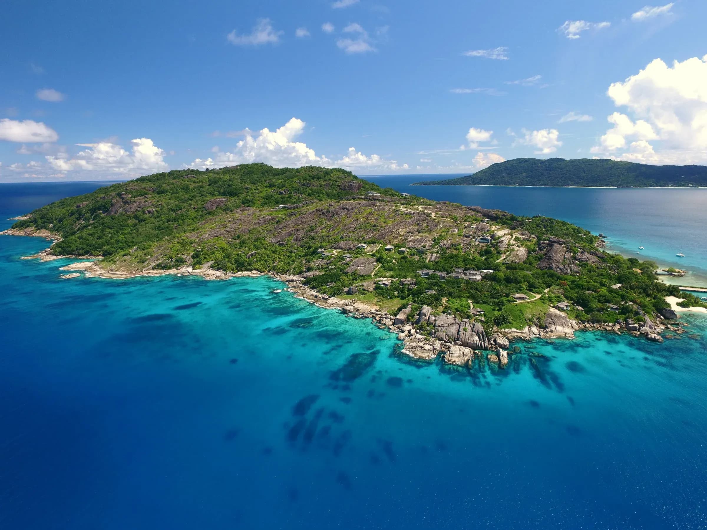 Aerial view of Félicité Island and Six Senses Zil Pasyon set among granite headlands, Seychelles
