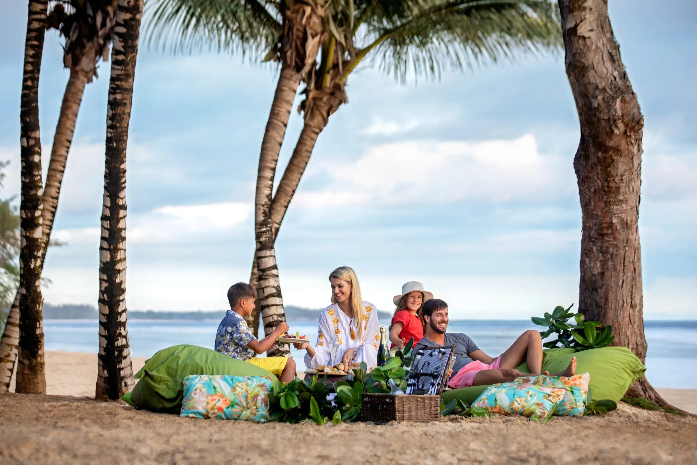 Family picnic beneath palm trees on the beach at SO Sofitel Mauritius
