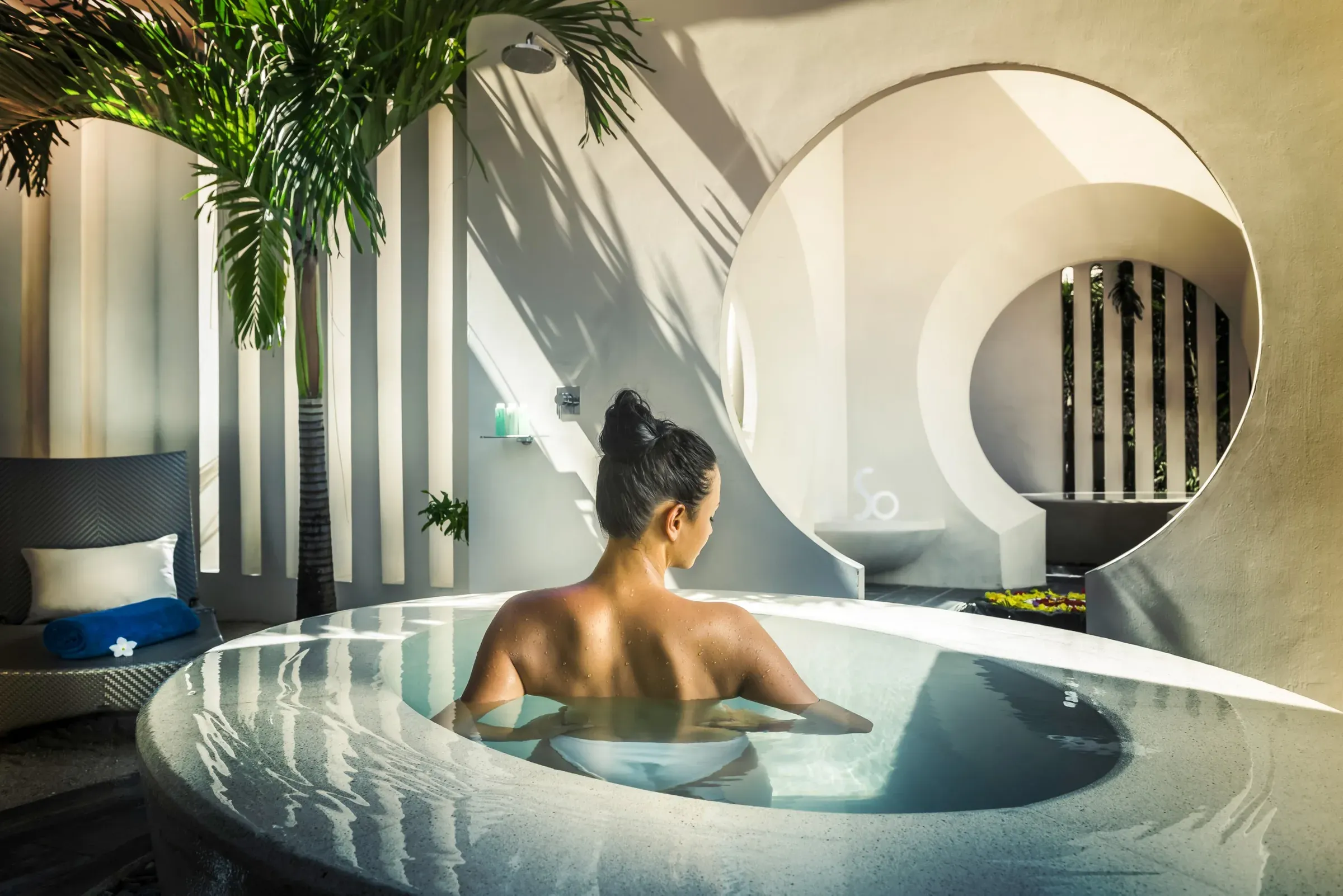 Guest relaxing in an open-air plunge pool at SoSPA, SO Sofitel Mauritius