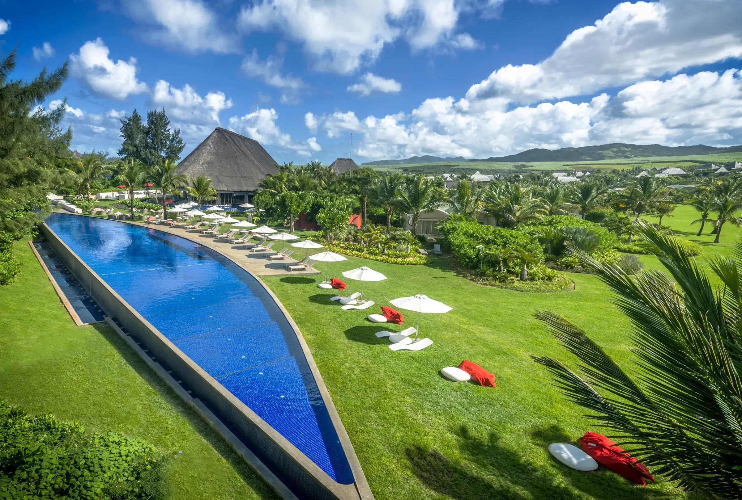 Aerial view of the panga-knife-shaped infinity pool and beachfront gardens at SO Sofitel Mauritius, Bel Ombre