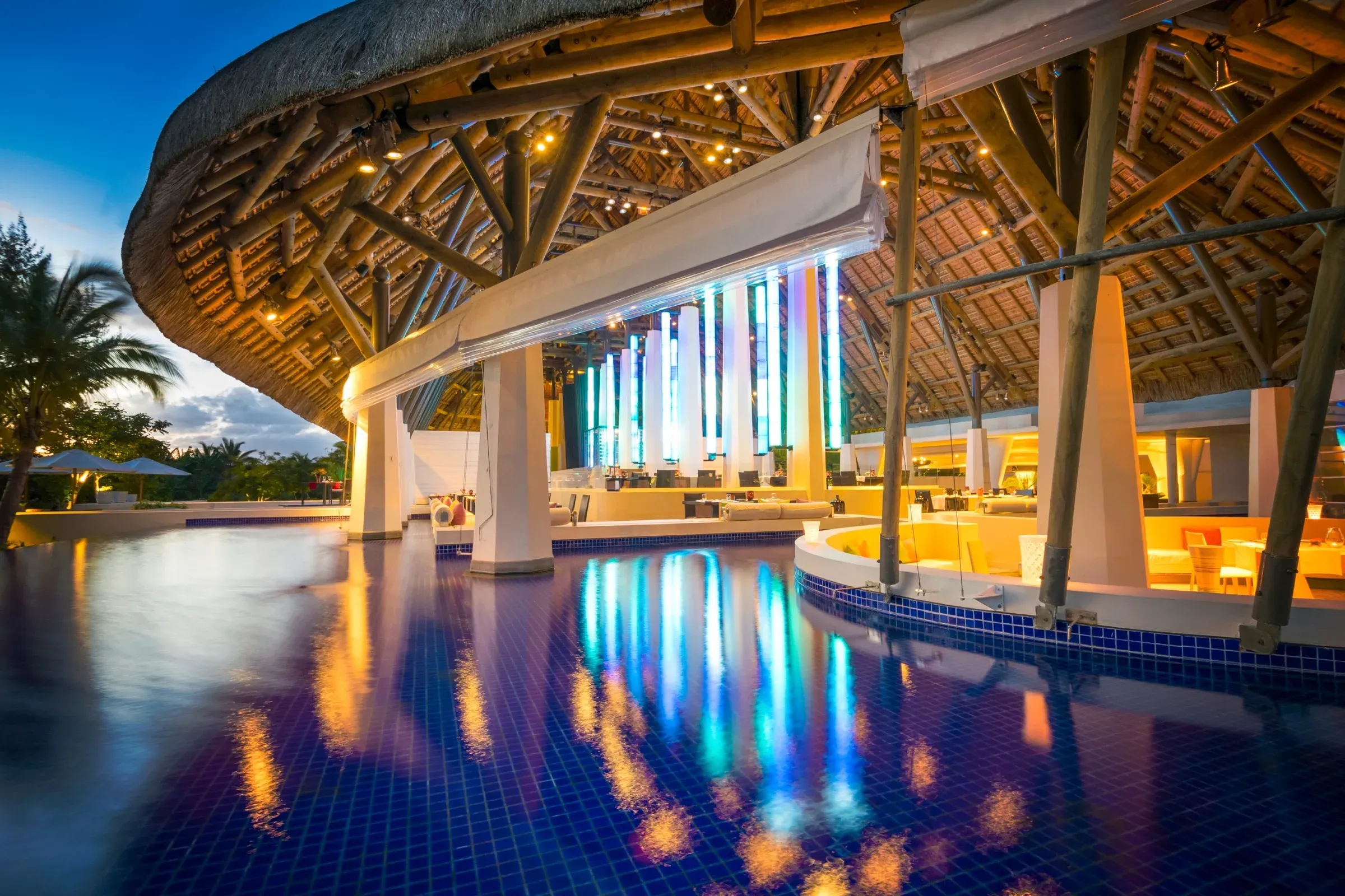 Le Flamboyant restaurant dining room beneath a thatched roof at SO Sofitel Mauritius