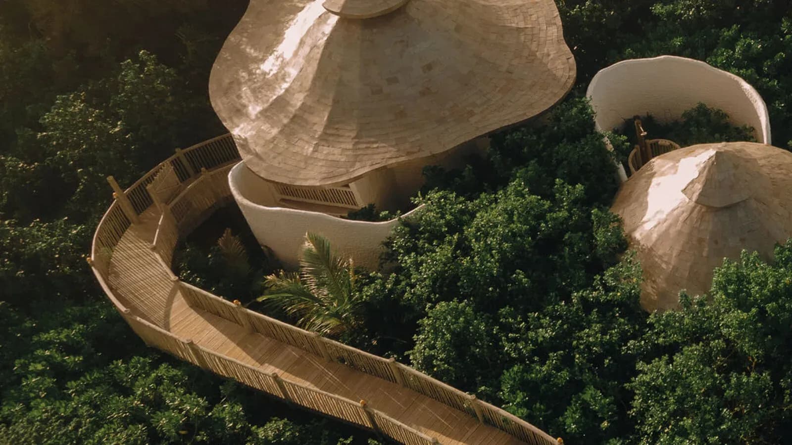 Aerial view of wooden walkways leading to the dome-shaped, thatched-roof Soneva Soul wellness pavilions at Soneva Jani