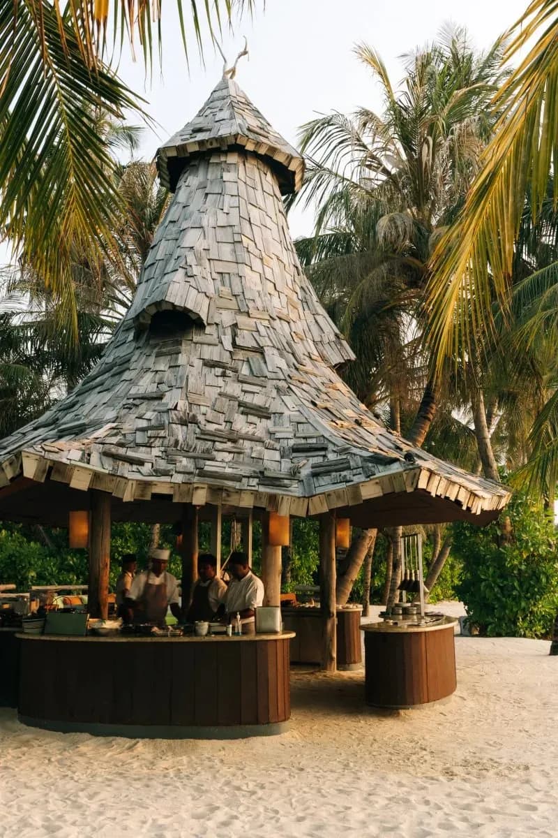 Open-fire beach dining setting at Primitive, Soneva Jani