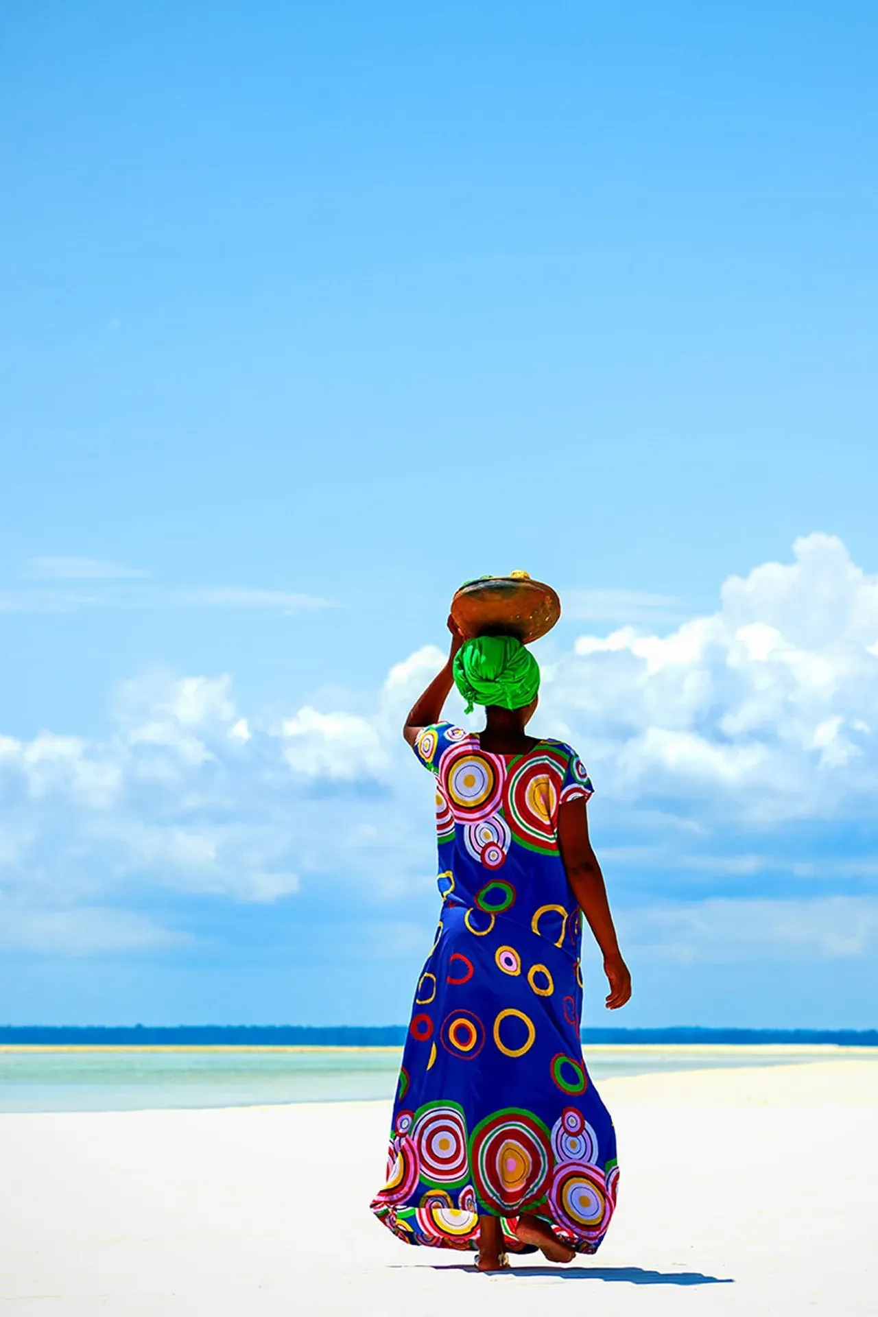 Local woman in traditional dress walking the beach near The Aiyana, Pemba Island