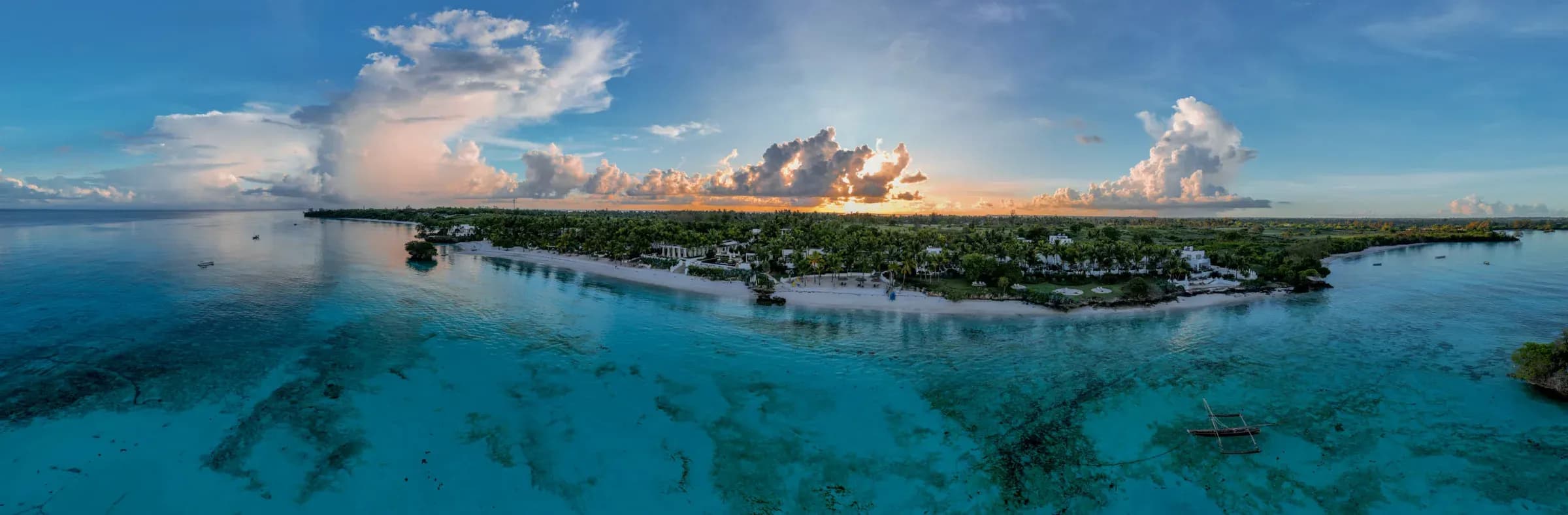 Aerial view of The Aiyana's beach and palm-fringed villas at dusk, Pemba Island