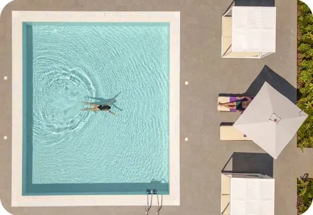Aerial view of a swimmer in one of the six pools at The Mora Zanzibar